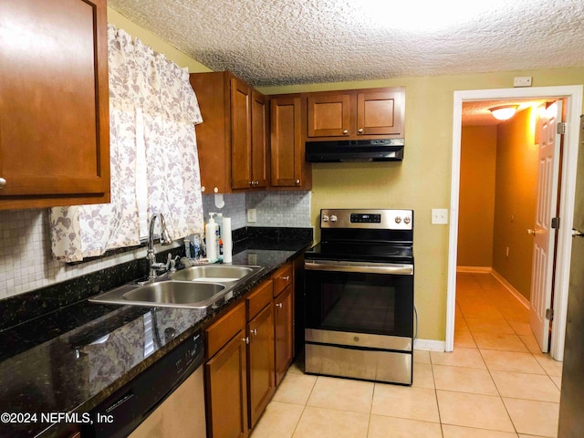 kitchen with sink, tasteful backsplash, stainless steel appliances, and dark stone counters