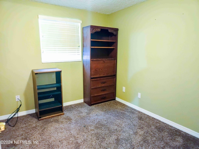 unfurnished bedroom featuring light carpet and a textured ceiling