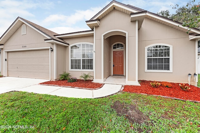 single story home featuring a garage and a front yard