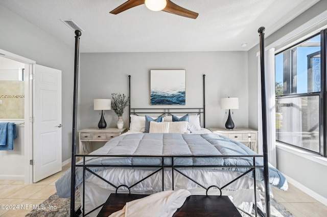 tiled bedroom with ceiling fan and a textured ceiling