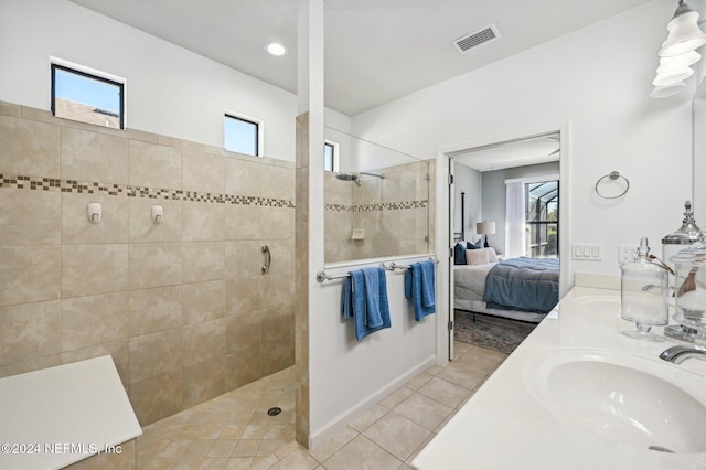 bathroom with tile patterned floors, vanity, and tiled shower