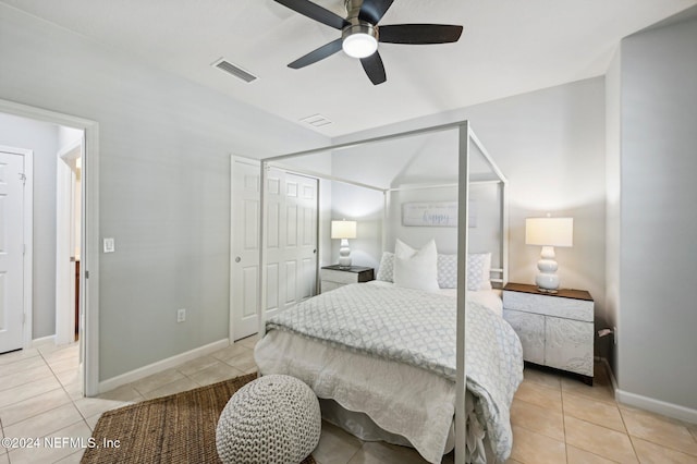 tiled bedroom with ceiling fan and a closet