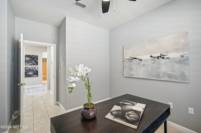 tiled office space featuring a textured ceiling