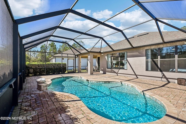 view of swimming pool with a lanai and a patio