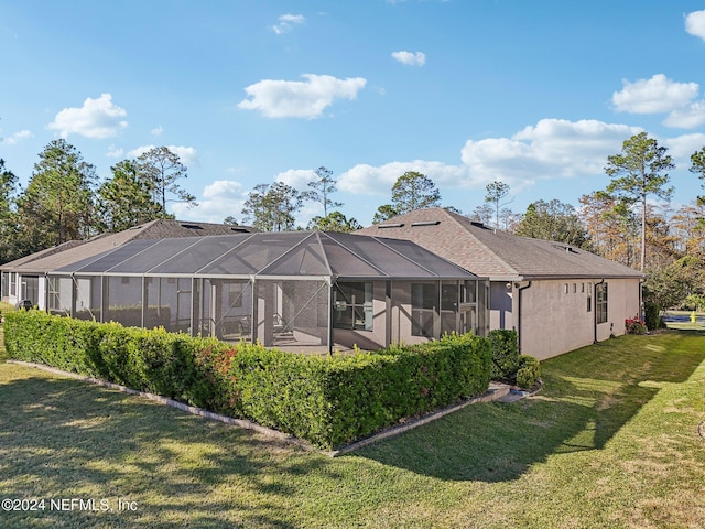 rear view of property with a lanai and a yard