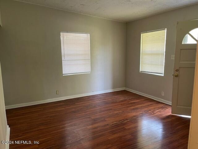 foyer featuring dark hardwood / wood-style flooring and a textured ceiling