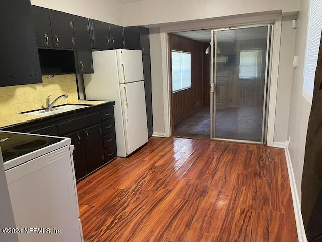 kitchen with white appliances, backsplash, sink, and dark hardwood / wood-style flooring