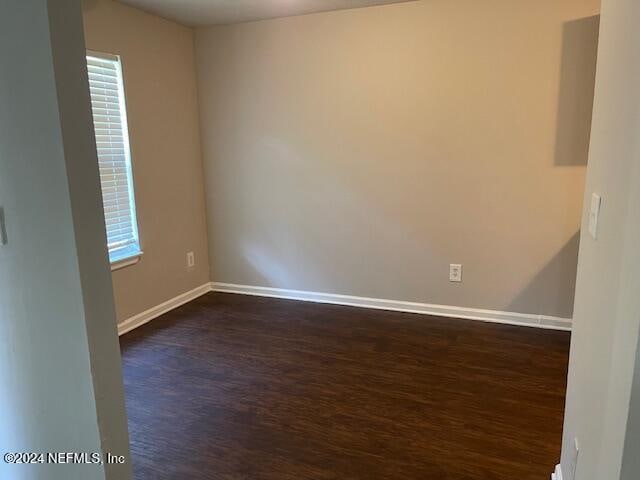 empty room with dark hardwood / wood-style flooring