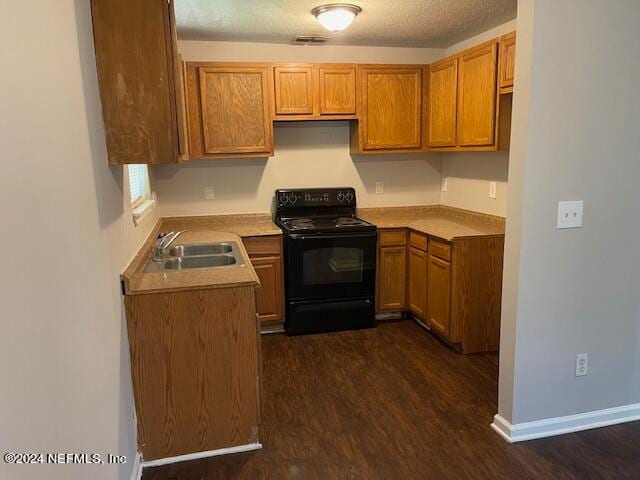 kitchen featuring sink, black / electric stove, dark wood-type flooring, and a textured ceiling