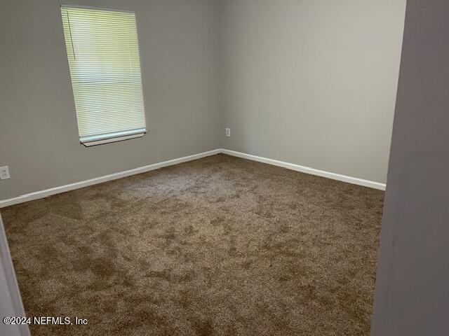 carpeted spare room featuring plenty of natural light