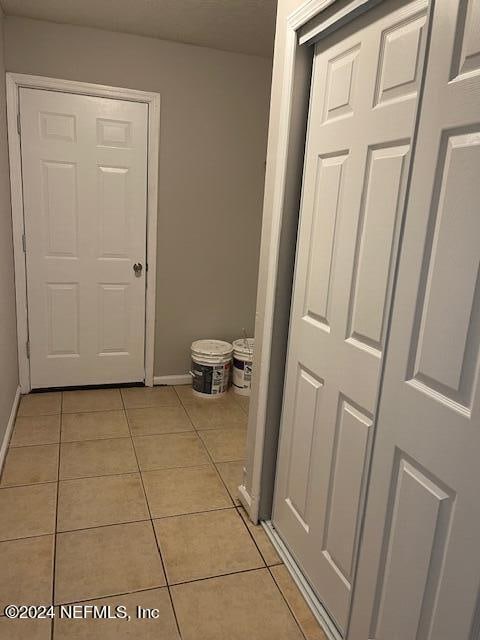 hall featuring light tile patterned floors