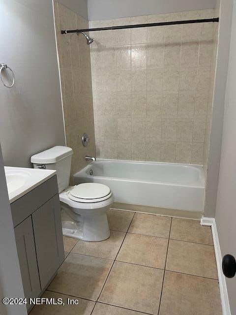 full bathroom with tiled shower / bath, vanity, toilet, and tile patterned floors