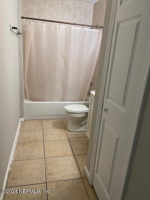 bathroom with shower / bath combination with curtain, toilet, and tile patterned flooring