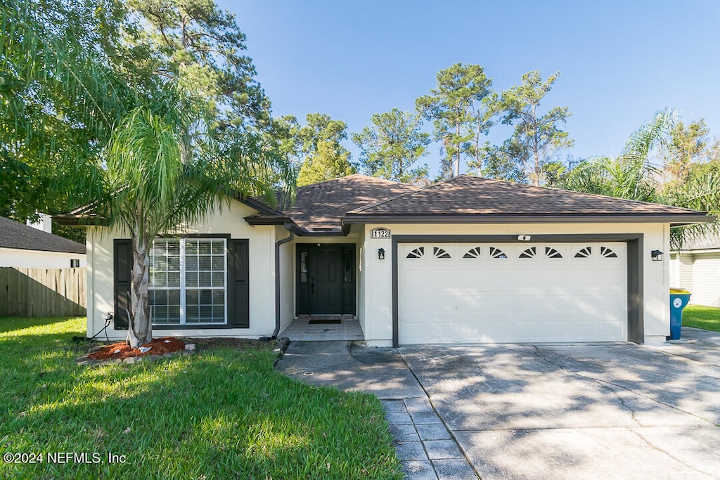 ranch-style home featuring a garage and a front lawn