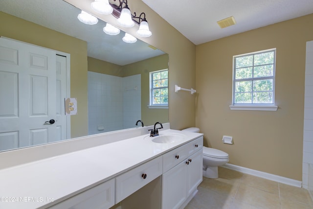 bathroom featuring toilet, a healthy amount of sunlight, vanity, and tile patterned floors