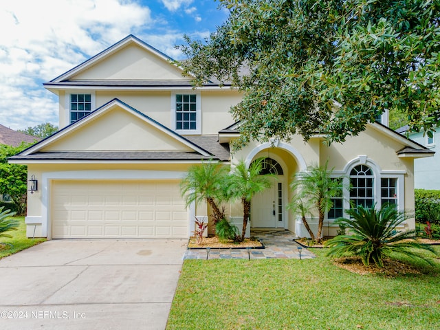 view of front of home with a front yard and a garage