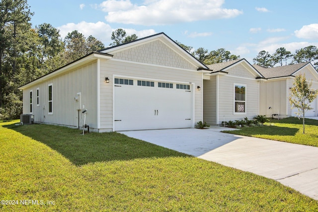 view of front of home featuring a front yard, central AC, and a garage