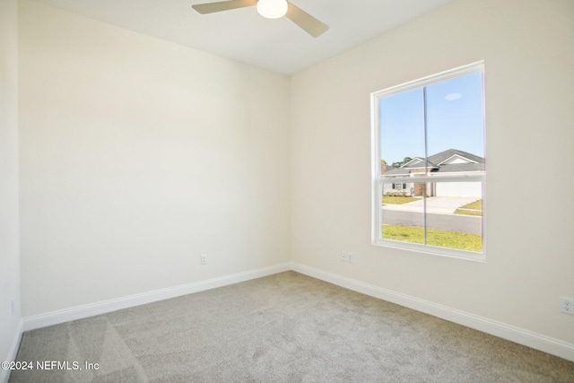 carpeted spare room with ceiling fan