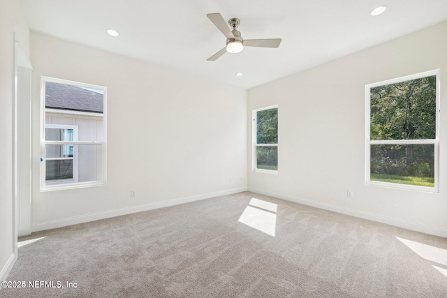 spare room featuring light colored carpet and ceiling fan