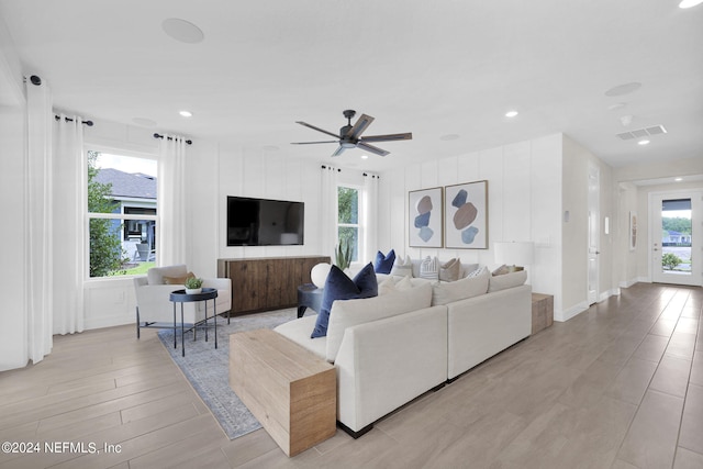 living room with ceiling fan and light hardwood / wood-style flooring