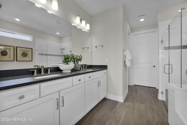 bathroom with a shower with door, hardwood / wood-style flooring, and vanity