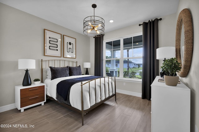 bedroom with a notable chandelier and hardwood / wood-style flooring