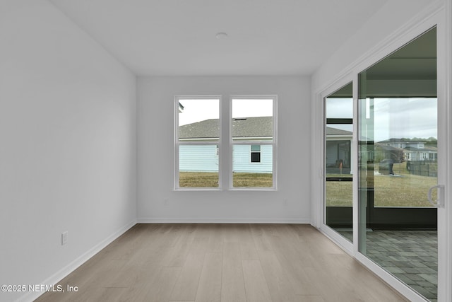 empty room with light wood-style floors and baseboards