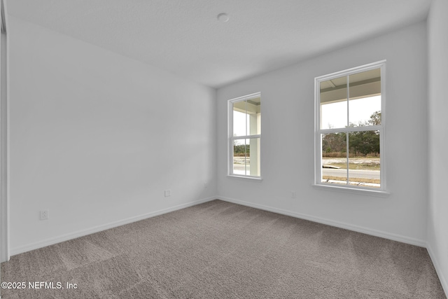 empty room featuring carpet flooring and baseboards