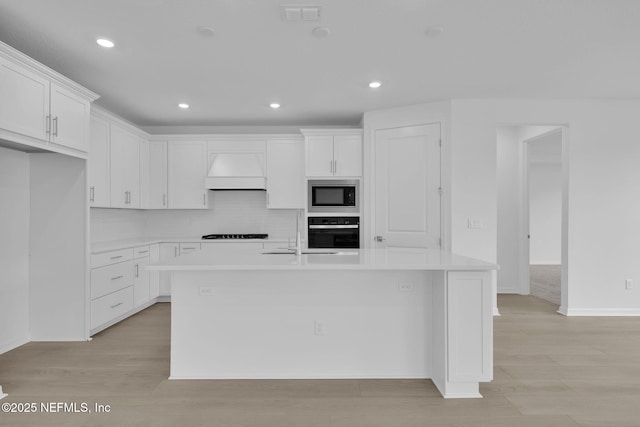 kitchen with visible vents, custom exhaust hood, built in microwave, oven, and white cabinets