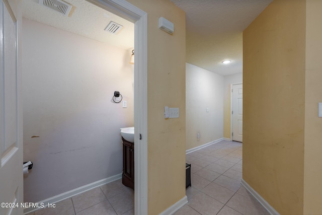 bathroom featuring vanity, tile patterned floors, and a textured ceiling