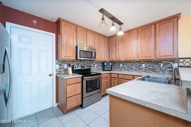 kitchen with a textured ceiling, stainless steel appliances, sink, and backsplash