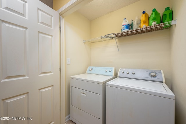 washroom featuring a textured ceiling and washer and clothes dryer