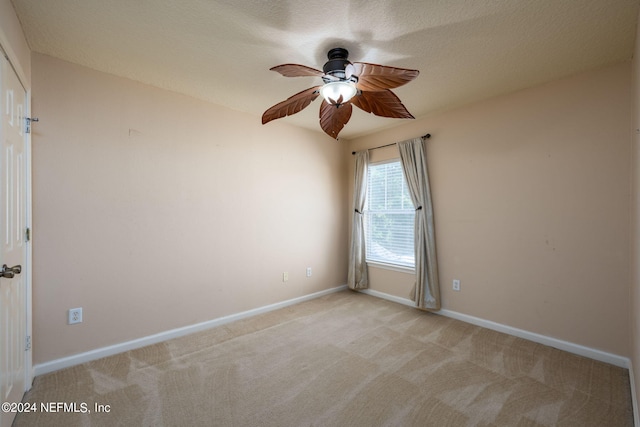 unfurnished room featuring ceiling fan, a textured ceiling, and light colored carpet