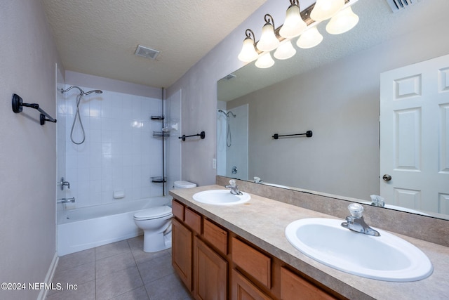 full bathroom with tile patterned floors, toilet, tiled shower / bath combo, vanity, and a textured ceiling