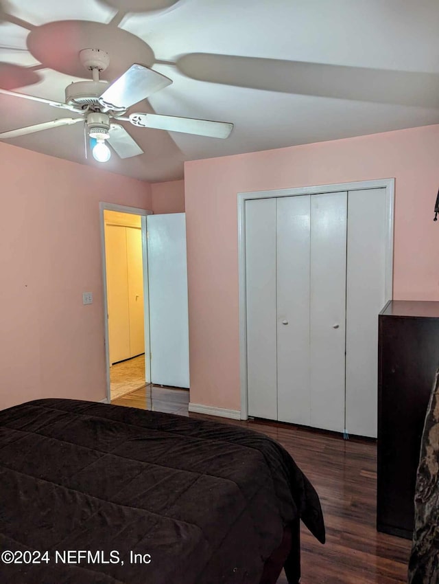 bedroom featuring ceiling fan, a closet, hardwood / wood-style floors, and lofted ceiling