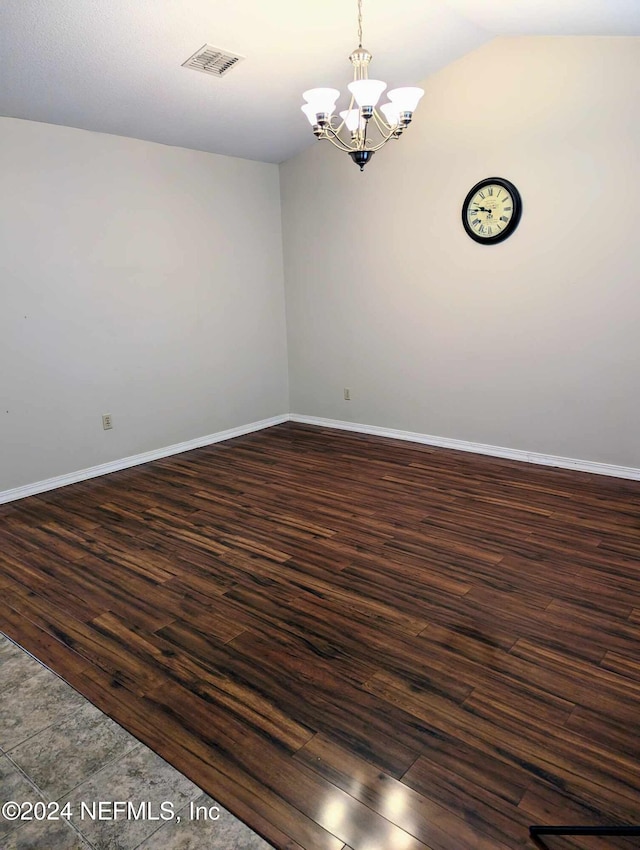 unfurnished room featuring vaulted ceiling, a chandelier, and dark wood-type flooring