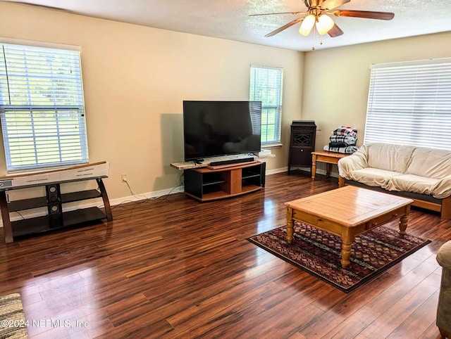 living room featuring ceiling fan, plenty of natural light, and dark hardwood / wood-style floors