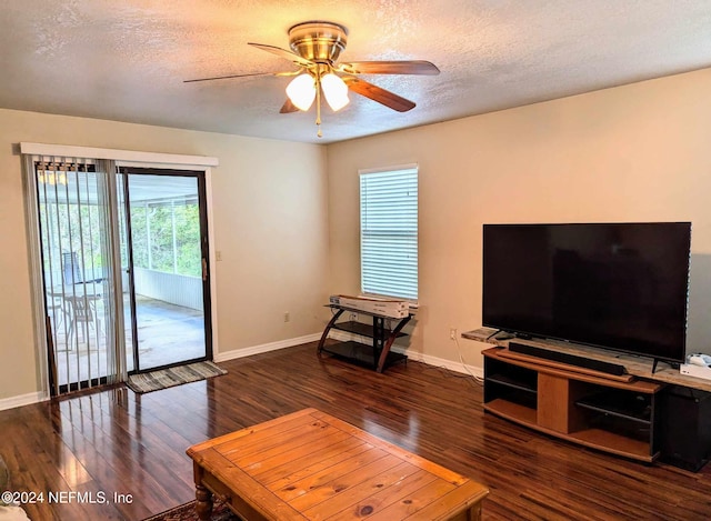 living room featuring dark hardwood / wood-style floors, a textured ceiling, and ceiling fan