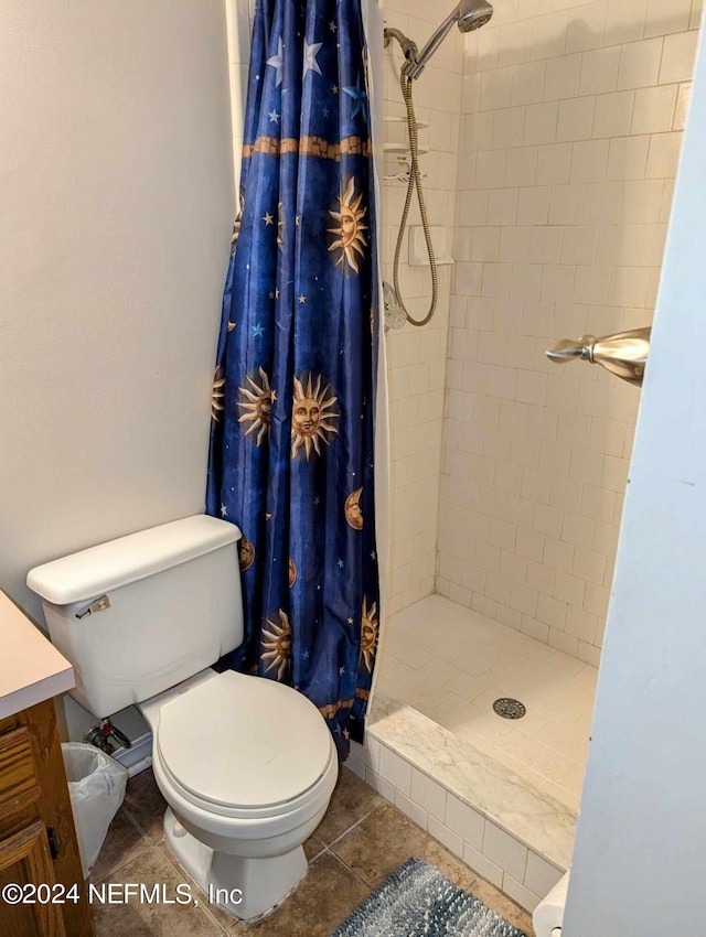 bathroom featuring tile patterned flooring, walk in shower, vanity, and toilet