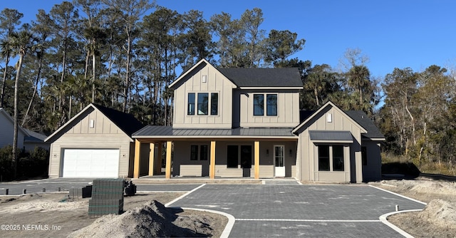 modern inspired farmhouse featuring a garage and a porch