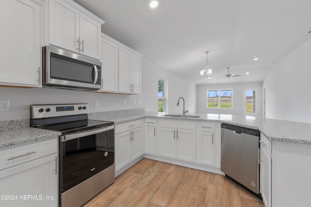 kitchen with white cabinets, stainless steel appliances, sink, and kitchen peninsula