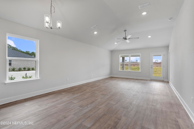 unfurnished room featuring ceiling fan with notable chandelier, light wood-type flooring, and lofted ceiling