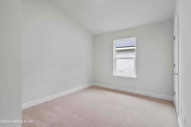 unfurnished room with lofted ceiling and carpet flooring