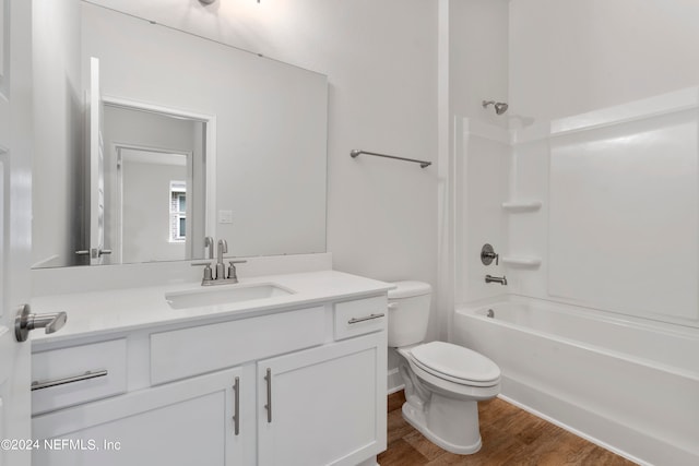 full bathroom featuring bathing tub / shower combination, wood-type flooring, vanity, and toilet