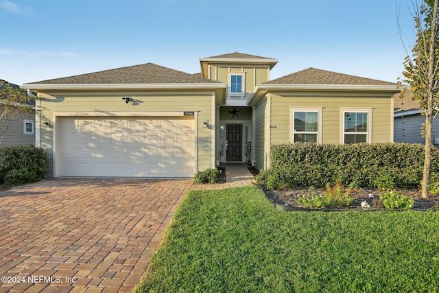 view of front of property with a front yard and a garage