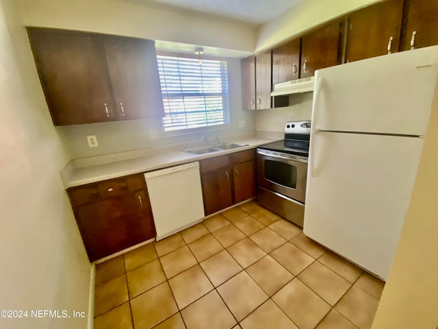 kitchen featuring white appliances, light tile patterned floors, and sink