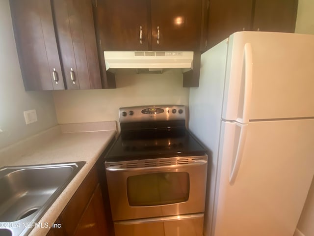 kitchen featuring sink, stainless steel electric range, and white fridge