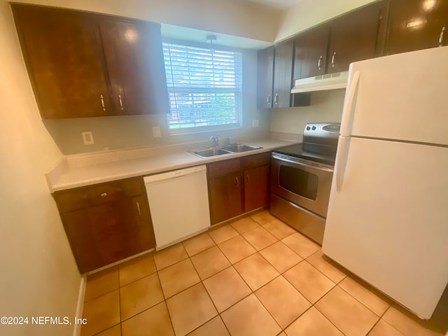 kitchen featuring sink, light tile patterned floors, and white appliances