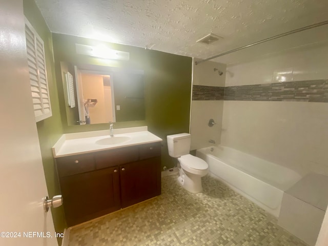 full bathroom featuring toilet, tiled shower / bath, a textured ceiling, and vanity