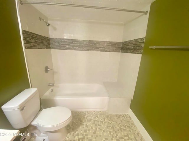 bathroom with tiled shower / bath combo, toilet, and tile patterned flooring